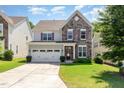 Charming two-story home featuring a stone facade, manicured lawn, and a two-car garage at 1127 Timbercut Dr, Durham, NC 27703