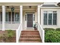 Inviting front porch with brick steps, white railings, and manicured landscaping at 117 Garden Oaks Dr, Smithfield, NC 27577