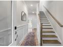 Inviting foyer with wainscoting, a staircase, and an accent mirror for added appeal at 124 Sugar Run Dr # 11, Fuquay Varina, NC 27526