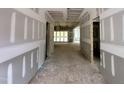 View of a hallway in progress, with a glimpse of the exterior and unfinished walls at 155 Cherry Bark Dr, Youngsville, NC 27596