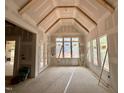 A sun room with an unfinished ceiling and a wall of windows at 155 Cherry Bark Dr, Youngsville, NC 27596