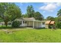 Charming one-story home featuring a covered porch, well-maintained lawn, and lovely landscaped surroundings at 16 S Church, Coats, NC 27521