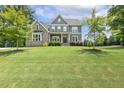 Beautiful two-story home with stone and gray siding and a lush green lawn at 1625 Banks View Dr, Raleigh, NC 27603
