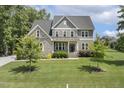 Charming two-story home with stone accents, well-manicured lawn, and mature trees at 1625 Banks View Dr, Raleigh, NC 27603