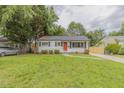 Charming single-story home featuring a well-maintained lawn and an inviting orange front door at 1708 Forest Rd, Durham, NC 27705