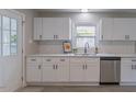 Bright kitchen with white cabinets, stainless steel appliances, and a window overlooking the yard at 1708 Forest Rd, Durham, NC 27705