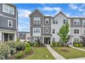 Well-maintained gray and white two-story townhome with lush landscaping and a sidewalk at 1729 Starlit Sky Ln, Cary, NC 27519