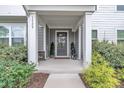 Inviting covered front porch with gray siding, columns, and landscaped shrubbery at 1729 Starlit Sky Ln, Cary, NC 27519