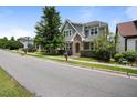 Charming two-story home features a manicured lawn, brick accents, and a welcoming yellow front door at 1962 Briar Chapel Pkwy, Chapel Hill, NC 27516