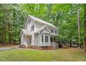 Lovely home showcasing a well-maintained lawn, mature trees, and a side entry porch with white railings at 201 Cobblestone Dr, Chapel Hill, NC 27516