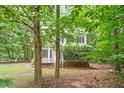 Inviting home nestled among mature trees, featuring a charming bay window and a landscaped front yard at 201 Cobblestone Dr, Chapel Hill, NC 27516