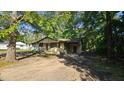 Modest single-story home with a rustic, woodsy feel and a shaded carport at 2100 N Webb St, Selma, NC 27576