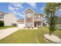 Well-kept two-story house featuring an attached garage, lush lawn, and inviting front entrance at 2309 King Malcolm Ln, Zebulon, NC 27597