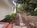 Scenic backyard featuring a brick-lined walkway, mature trees and lush landscaping at 2428 Perkins Rd, Durham, NC 27705