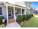 Inviting front porch featuring classic columns, tidy landscaping, and a welcoming entrance at 244 Lasswade Ct, Zebulon, NC 27597
