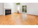 Bright living room with a fireplace and large windows overlooking the trees at 252 Fox Ridge, Pittsboro, NC 27312