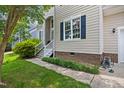 Exterior view of a home with pristine lawn and tidy landscaping near the front door at 304 Gold Point Dr, Cary, NC 27519