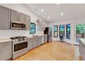 Bright kitchen with stainless steel appliances, gray cabinets, quartz counters and a sunny breakfast nook at 306 Roebling Ln, Cary, NC 27513