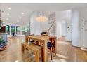 Open-concept living area with hardwood floors, a large dining table, and staircase leading to the second floor at 306 Roebling Ln, Cary, NC 27513