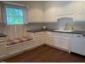 Bright kitchen with white cabinets, stainless appliances, and a window seat overlooking the yard at 3604 Woodlawn Rd, Rocky Mount, NC 27804