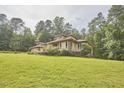 Low angle of a stylish single-story residence with beautiful landscaping, and a sprawling green lawn at 3605 Laurel Creek Way, Durham, NC 27712