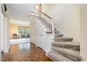 Inviting foyer with wood floors, a staircase, and access to a carpeted living room, providing a warm welcome at 384 Lyndfield Cl W, Pittsboro, NC 27312