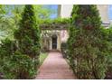 Inviting brick pathway leading to the front entrance with an overhead trellis covered in greenery at 4001 Falls River Ave, Raleigh, NC 27614