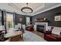 Elegant home office with fireplace, custom lighting, and refined finishes creating a productive workspace at 4001 Falls River Ave, Raleigh, NC 27614