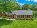 Aerial view of a single story brick home, green lawn, and mature landscaping at 417 N Gurney St, Burlington, NC 27215