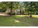 A picturesque front yard showcasing the home's exterior framed by mature trees and lush landscaping at 44 Supreme Dr, Lillington, NC 27546