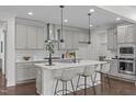 Bright kitchen features a large island with white countertops, pendant lighting, and gray cabinetry at 520 Flip Trl, Cary, NC 27513