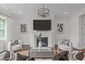 This living room showcases a fireplace, modern light fixture, and seating, creating a cozy and inviting space at 520 Flip Trl, Cary, NC 27513