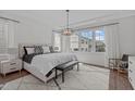 Bright primary bedroom with large windows, stylish furnishings, and hardwood floors at 520 Flip Trl, Cary, NC 27513