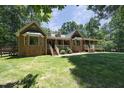 Rear view of the brick home with multiple gables and a covered porch at 5464 Bass Mountain Rd, Snow Camp, NC 27349