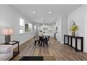 Open-concept living and dining area with wood floors, recessed lighting, and a kitchen in the background at 55 Baldwin St, Lillington, NC 27546