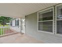 Covered side porch featuring gray siding and white railings, providing a cozy outdoor space at 558 Christys Way, Roxboro, NC 27574