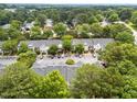 Aerial view of townhome community featuring tree lined streets and plentiful parking at 5717 Corbon Crest Ln, Raleigh, NC 27612