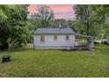 Exterior of the home showing a large, grassy backyard and covered parking area at 603 S Third St, Mebane, NC 27302