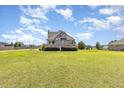 Attractive home with a spacious front yard and healthy grass under a blue, cloudy sky at 656 Atkins Rd, Fuquay Varina, NC 27526