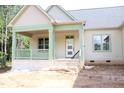 Inviting front porch with brick base and green trim, perfect for relaxing and enjoying the view at 70 Basil Ct, Franklinton, NC 27525