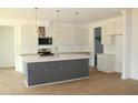 Modern kitchen with a large island, stainless steel appliances, and pendant lighting fixtures at 70 Basil Ct, Franklinton, NC 27525