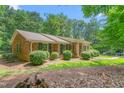 Charming brick home featuring a well-manicured lawn, lush landscaping, and a welcoming front entrance at 712 Orange High School Rd, Hillsborough, NC 27278