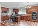 Well-equipped kitchen boasts stainless steel appliances, island, and stylish tile flooring at 760 Stackhurst Way, Wake Forest, NC 27587