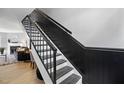 Elegant staircase featuring contrasting black and white colors and a view of the living space at 7708 Falcon Rest Cir, Raleigh, NC 27615