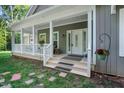 Inviting front porch with decorative columns, a white railing, and stylish details at 8226 Mcarthur Park Dr, Efland, NC 27243