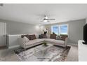 Cozy living room with a large sectional sofa, decorative pillows, a modern coffee table, and a ceiling fan at 89 Merle Dr, Wendell, NC 27591