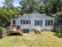 Rear view of a charming home featuring a wooden deck and a spacious backyard at 101 Goldston Dr, Carrboro, NC 27510