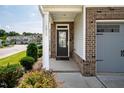 Inviting front porch with brick accents, manicured shrubs, and a stylish glass front door at 1018 Excite Ave, Morrisville, NC 27560