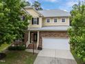 A view of a two-story home with stone and siding, a two-car garage, and well-maintained landscaping at 1040 Bellenden Dr, Durham, NC 27713