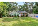 Traditional home with a well-kept lawn, complemented by lush trees and a white fence at 106 Lattimore Ln, Durham, NC 27713